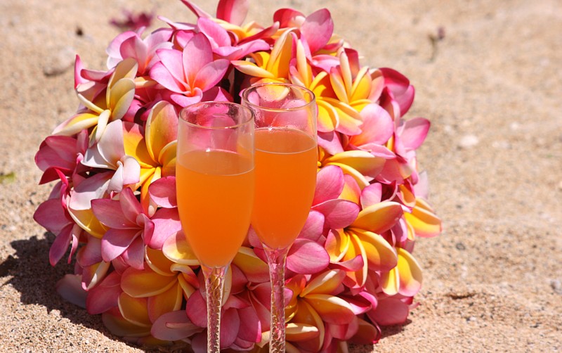 guava drink in champagne glasses with plumeria bouquet