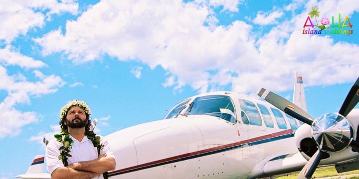A white airplane on the runway under a blue Hawaiian sky