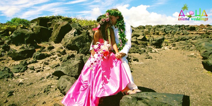 Paul and Dewi sharing a kiss on the lava rocks, Dewi in a flowing pink gown