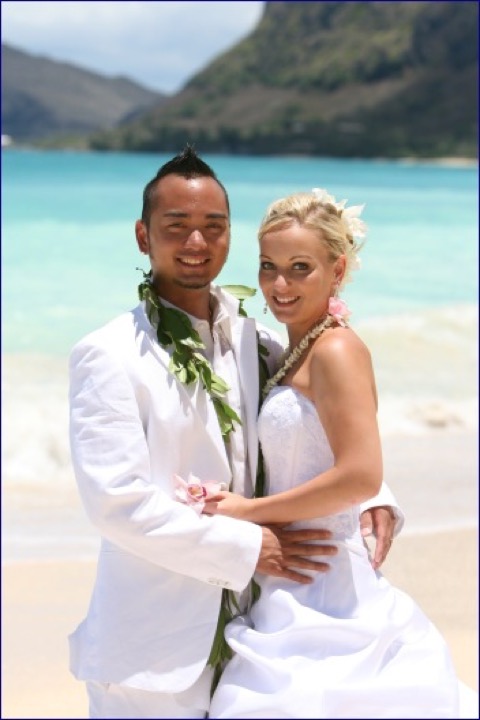 Angela and Chris smiling cheek to cheek by the ocean