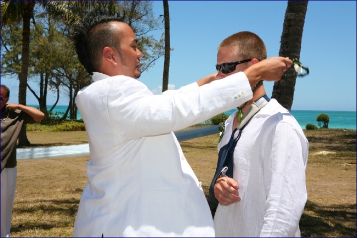 Chris placing a lei on one of his groomsmen on the lawn