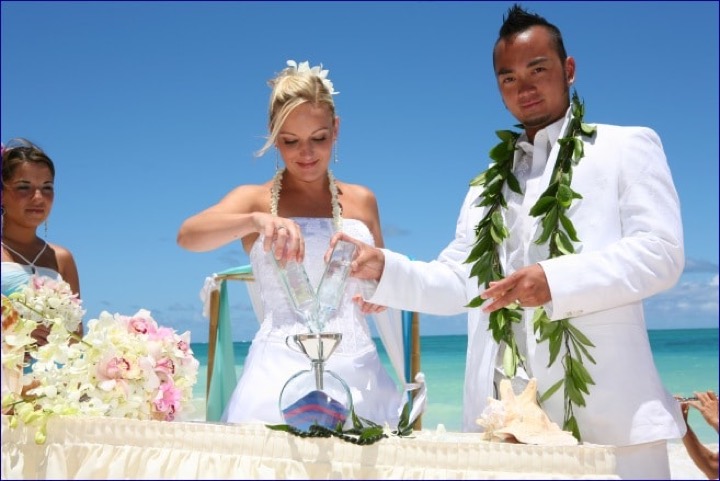 Angela and Chris pouring turquoise and pink sand together in their sand ceremony