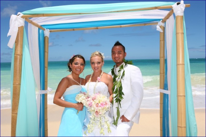 Angela and Chris with a bridesmaid under the turquoise arch