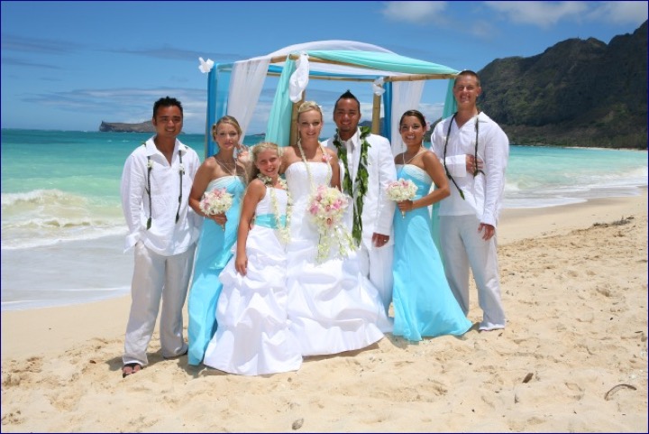 The bridal party in turquoise and white with green mountains behind