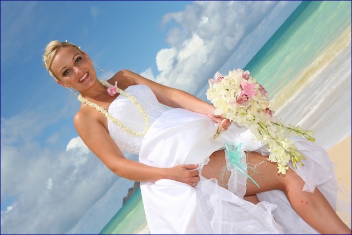 Angela posing with her bouquet under a blue sky