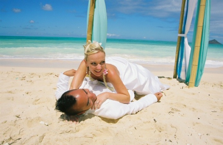 Chris and Angela lying in the sand in front of the arch
