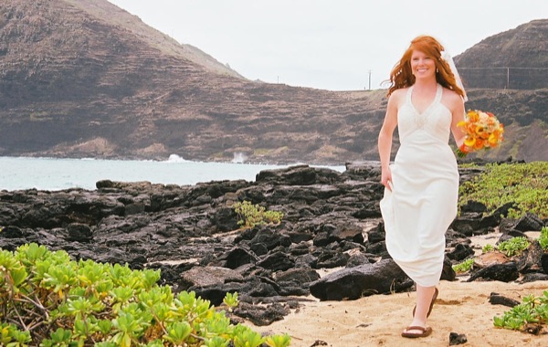 Ashley with her orange bouquet by the lava rocks, from another angle