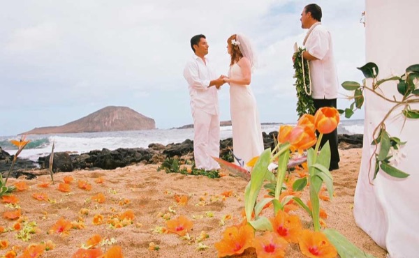 Ashley and her groom during the ceremony by the lava rocks, in the sunshine