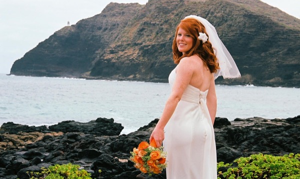 Ashley with her orange bouquet by the lava rocks