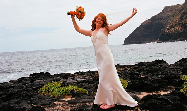 Ashley throwing her orange bouquet in the air by the sea, close up