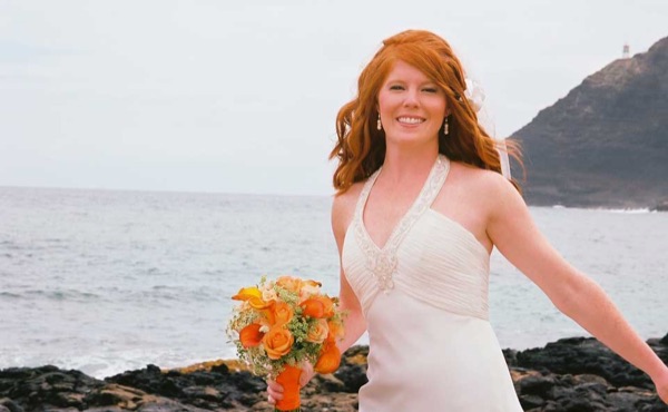 Ashley with her orange bouquet by the lava rocks, close up
