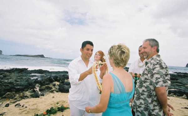 Ashley's wedding ceremony on the beach, under a blue sky