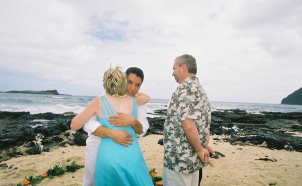 Ashley and her groom during the ceremony by the lava rocks, under a blue sky