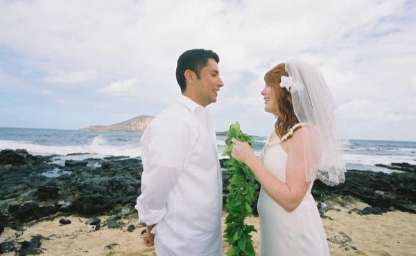 Ashley and her groom during the ceremony by the lava rocks, wide view