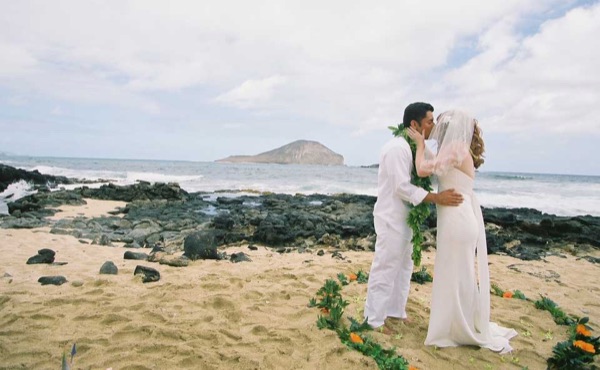 Ashley and her groom during the ceremony by the lava rocks, looking at each other