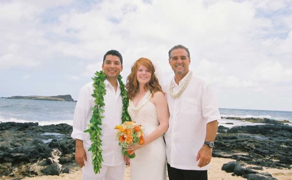 Ashley and her groom with family on the beach
