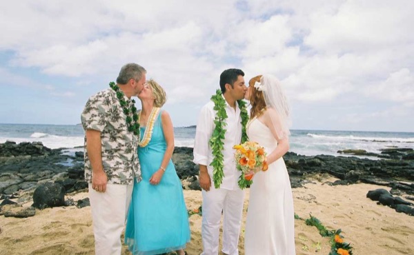 Ashley and her groom with family on the beach, close up