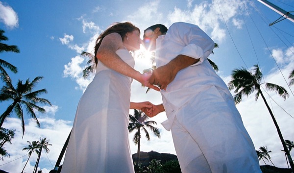 Ashley and her groom in the water at Lanikai, smiling