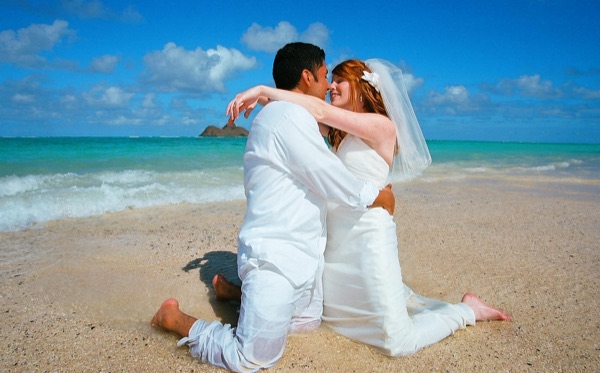 A kiss under the palms at Lanikai, in the sunshine