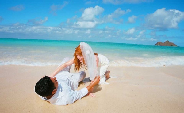 A kiss under the palms at Lanikai, under a blue sky