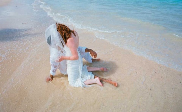 Ashley and her groom in the water at Lanikai, wide view