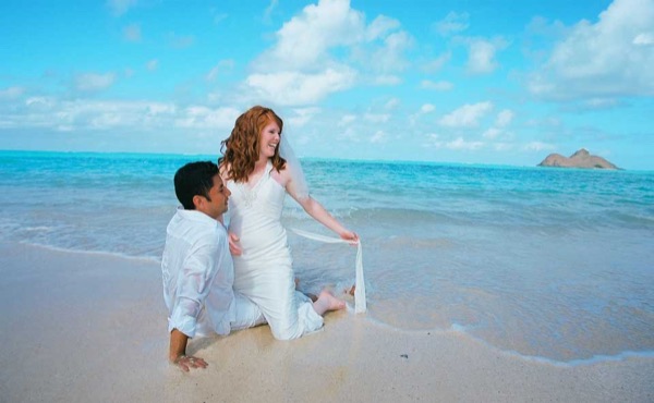 Ashley and her groom in the water at Lanikai, looking at each other