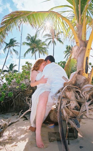 Ashley and her groom under a palm tree at Lanikai ur, side by side