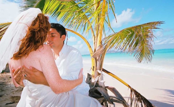 Ashley and her groom under a palm tree at Lanikai, side by side