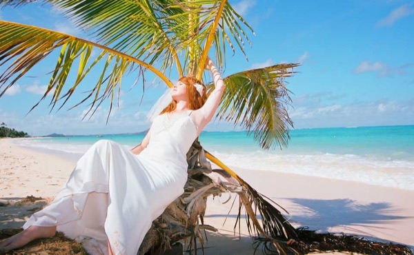 Ashley and her groom under a palm tree at Lanikai, close up