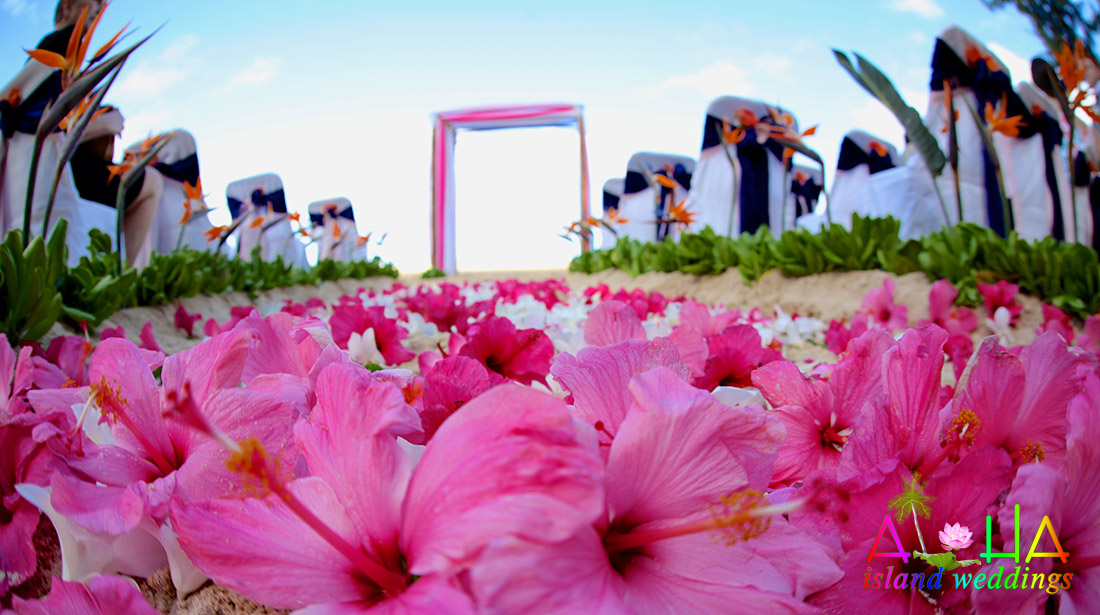 Bright fuchsia pink orchids for the beginning on the island way flowers on this blue and orange and pink themed Hawaiian wedding