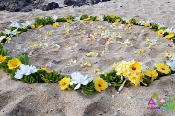 A flower circle of yellow and white flowers on the sand