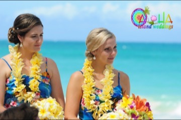 Bridesmaids wearing yellow plumeria leis by the ocean