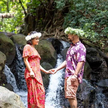 A couple in flower crowns by a waterfall