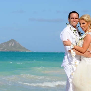 Stacy and Ken kissing on the beach on their photo tour