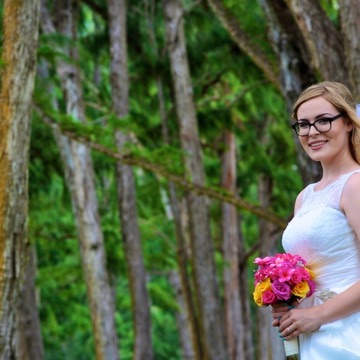 Rachelle holding her bouquet in the trees on her wedding day