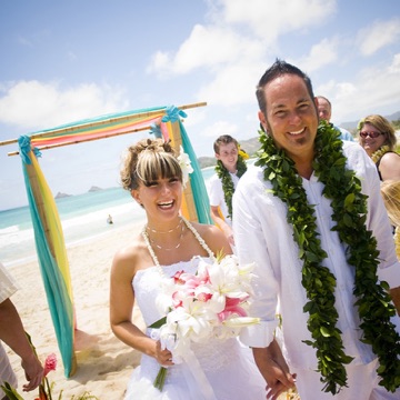 Becky and Eric in their leis on the beach at their Kailua estate wedding