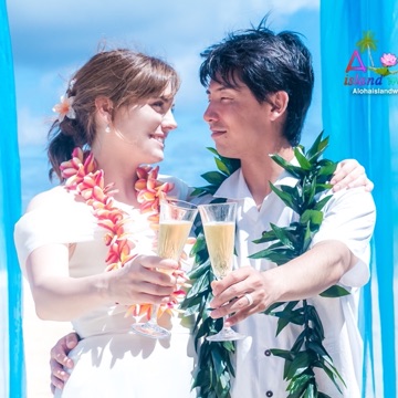 Toshi and Suzanne smiling under the arch after their ceremony
