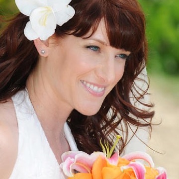 Elizabeth with a white flower in her hair holding her bouquet