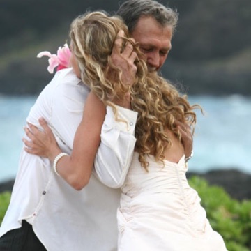 Jewel and Jamie hugging at their beach wedding