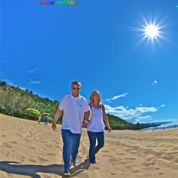 Krista and Charlie walking on the beach in the sunshine