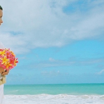 Kiley looking over the ocean with her pink and yellow bouquet