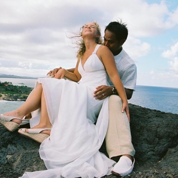 Tami and Albert sitting together on the rocks by the sea