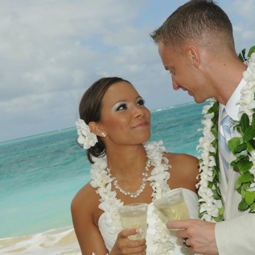 Rachel and Brandon smiling at each other by the ocean
