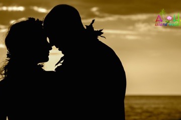 Silhouette of a couple kissing against a golden sunset