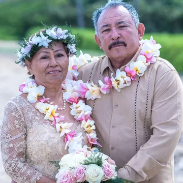 Rose and Carl cheek to cheek in their leis after 50 years