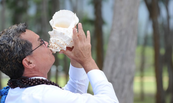 Rev. Kimo blowing the conch shell to announce the bride