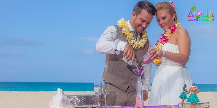 Pouring pink and white sand at a Hawaii beach wedding
