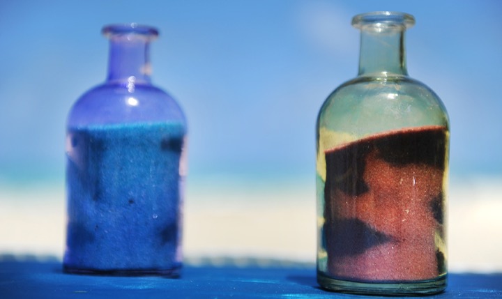 Brandy and Mike pouring ocean blue and pink sand together