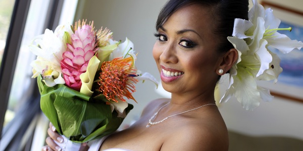 Bride holding her bouquet of lilies and protea