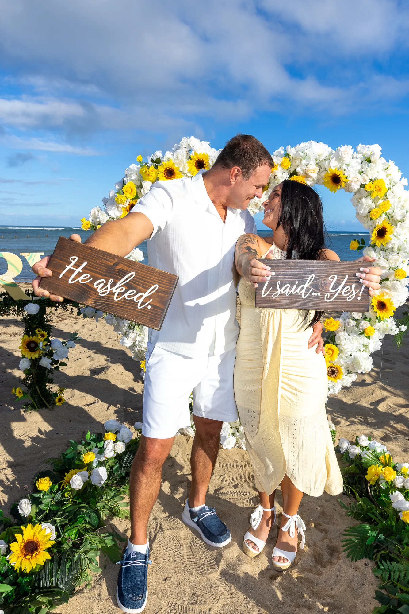 Holding the He asked and I said yes signs in the flower heart